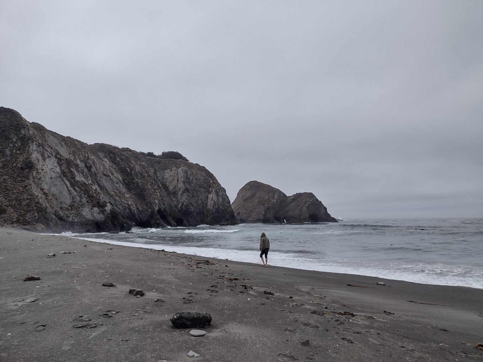 Greenwood beach on a cloudy day. One person can be seen walking along where the waves break