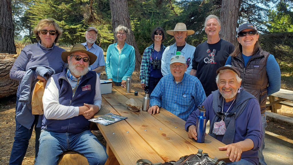 Mendocino Land Trust and Redwood Coast Land Conservancy board members sitting or standing around a bench