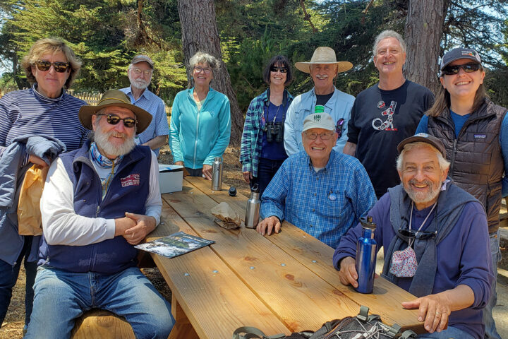 Mendocino Land Trust and Redwood Coast Land Conservancy board members sitting or standing around a bench